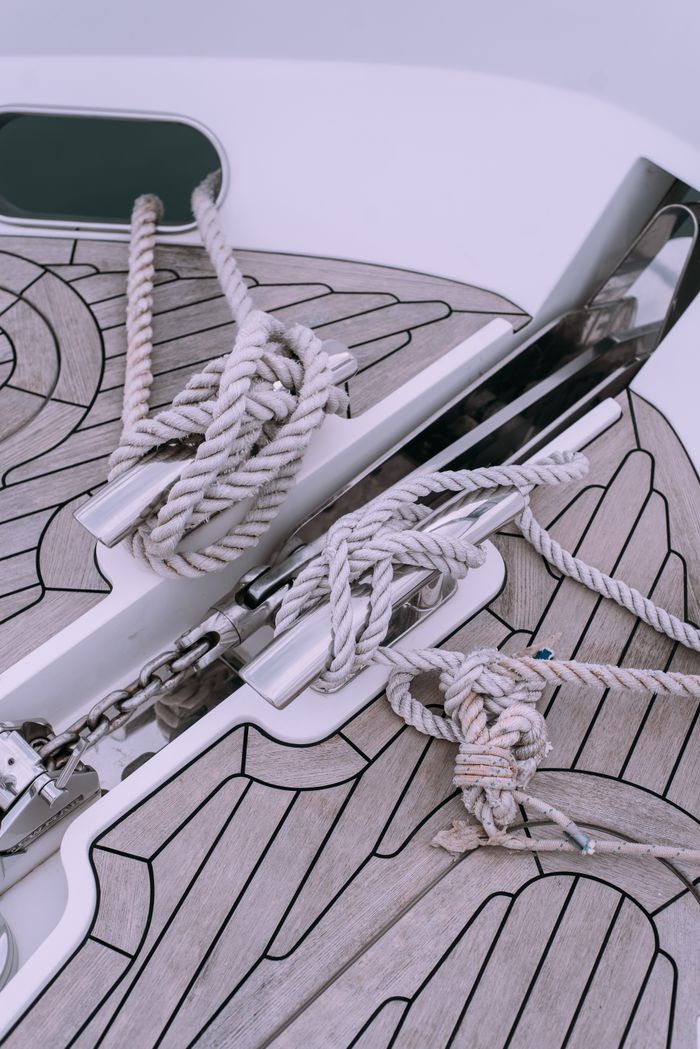 about-us-02 Close-up of nautical ropes organized on a yacht deck with metal fittings and wooden patterns, ideal for marine themes.
